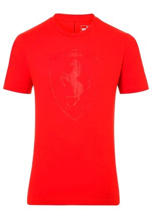 T-shirt en coton rouge à manches courtes, présentant une texture lisse et un logo Ferrari en relief subtil sur le devant.