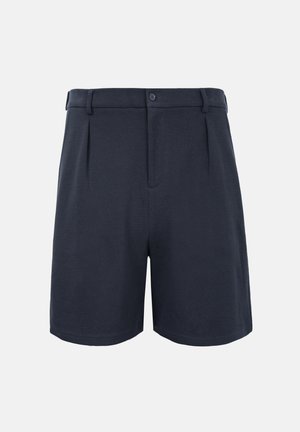 Shorts bleu marine cintrés avec fermeture à boutons sur le devant, passants pour ceinture, et plis subtils, sur un fond clair uni.