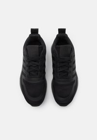 Chaussures de sport noires avec tige en mesh et synthétique, design à trois bandes, bout rond, col rembourré et semelle texturée pour une meilleure adhérence.