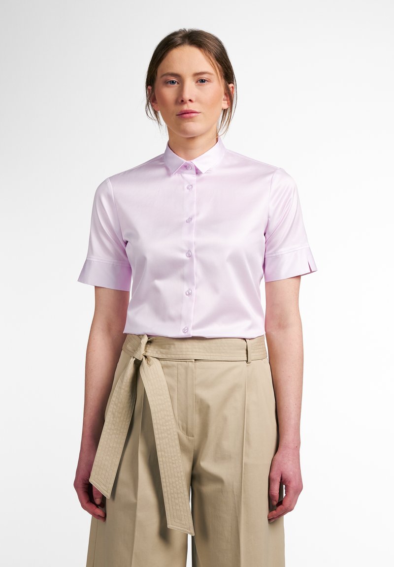 Camicia a maniche corte, di un rosa chiaro, con bottoni, realizzata in un tessuto liscio, caratterizzata da un colletto classico e dettagli sottili ai polsini.