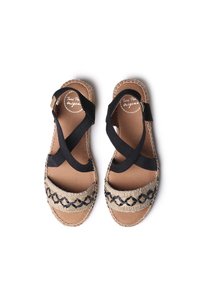 Espadrillessandaalit, joissa on kudottu beige yläosa mustilla yksityiskohdilla, ristikkäiset kangasremmit ja teksturoitu pohja.
