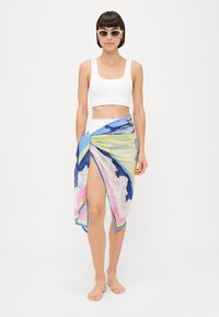 Sciarpa avvolgente leggera e colorata con un design a onde in tonalità di blu, rosa e verde. Tessuto trasparente con una caduta fluida.