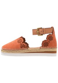 Espadrilla in suede arancione con ritagli floreali, cinturino alla caviglia, soletta in juta intrecciata, suola in gomma bianca e bordi scallop.