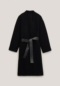 Sort lang frakke med en indviklet design og et matchende stofbånd. Teksturen ser blød ud, og den har brede ærmer og ingen lukninger.