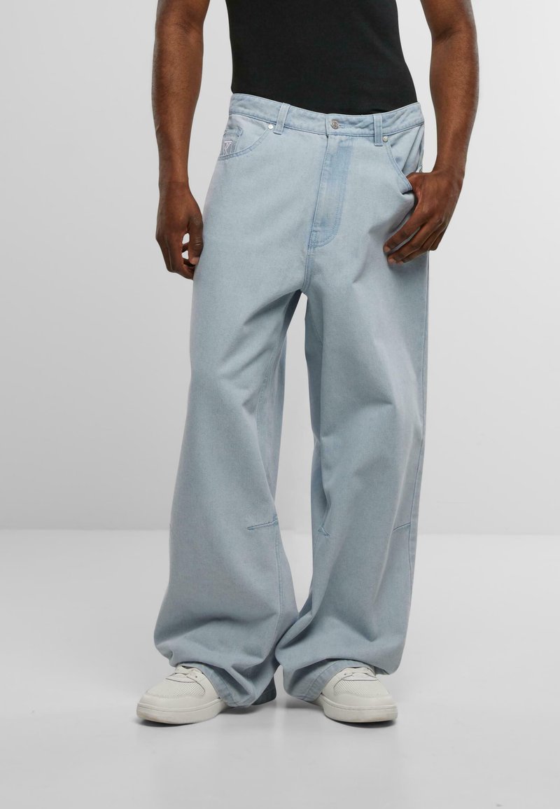 Jeans holgados de mezclilla en color azul claro, con diseño de pierna recta, detalles de costura sutiles y una cintura ancha.