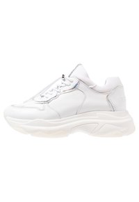 Zapatilla blanca con parte superior de cuero texturizado, suela transparente gruesa, múltiples agujeros para los cordones y un acento plateado en el lateral.
