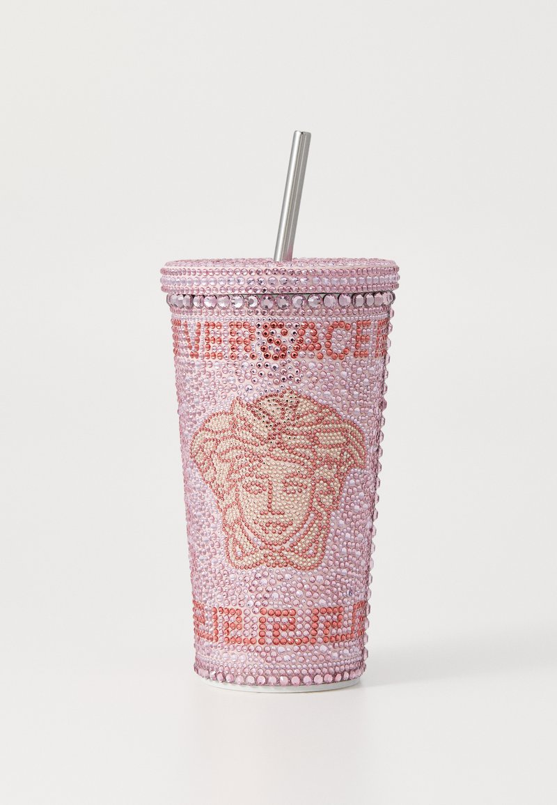 Vaaleanpunainen läpinäkyvä muki, jossa on vaaleanpunaisia ja kirkkaita strasseja, Medusa-logo ja "Versace"-teksti, sekä metallinen pilli.