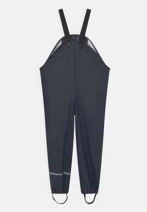 Tumši zili ūdensnecaurlaidīgi kombinezoni ar regulējamiem melniem siksnām, elastīgiem elastīgajiem piedurkņu galiem un atstarojošu joslu apakšā redzamībai.