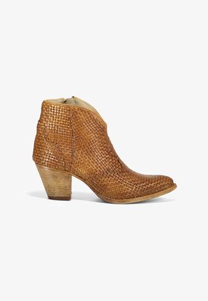 Tan gevlochten lederen enkelboot met een licht puntige neus, gestapeld houten hak en een open zijkant. De textuur is gedetailleerd en intricaat.
