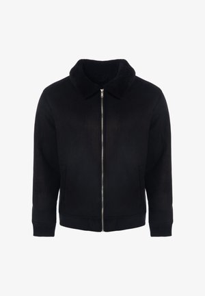 Juodas užtrauktuku užsegamas švarkelis su minkšta, tekstūruota apdaila ir aksomine apykakle. Turi ribotas rankogalius ir apačią, bei dvi priekines kišenes.