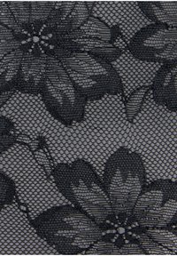 Tissu en dentelle florale noire présentant un design en maille avec de grands motifs floraux et une surface délicate et texturée.