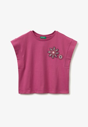 Korte mouw magenta cropped top met ronde hals en twee gehaakte bloemenpatches op de bovenste linkerborst.