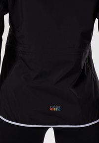 Giubbotto nero con una texture liscia, caratterizzato da un orlo bianco e un logo multicolore sul retro. Design leggero e casual.