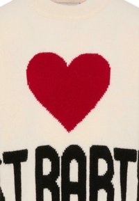 Gebreide sweater in crème, met een grote rode hart en vette zwarte letters. Ronde halslijn met geribbelde randen, zachte textuur.