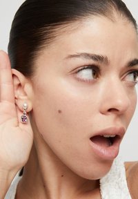 Pendientes de plata con una piedra preciosa rosa, forma ovalada, diseño colgante, con un acabado suave y un enganche redondo.