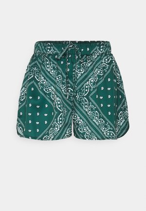 Short vert avec imprimé bandana paisley blanc, taille élastique et cordon à l'avant, présenté sur un fond uni.