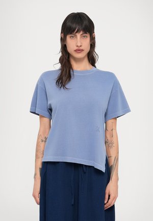 Light blue short-sleeve t-shirt with a round neckline and a slightly cropped hem, featuring subtle embroidered detail on the front.