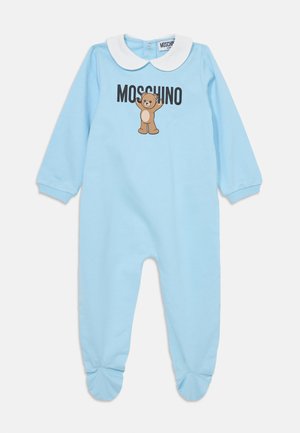 Mono de bebé azul claro con cuello blanco, que presenta un gráfico de un oso y el texto "MOSCHINO". Incluye parte inferior con pies y mangas largas.