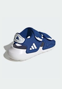 Niebieska sportowa sandał z białymi akcentami, z miękkim wierzchem, paskami na rzep, amortyzowaną podeszwą i otworami wentylacyjnymi.