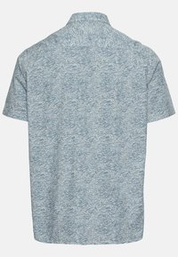 Camisa de manga corta en azul claro con un patrón de olas. Hecha de tejido texturizado, presenta un collar con botones y un ajuste relajado.