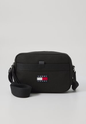 Czarna prostokątna torebka na ramię z regulowanym paskiem, przednią kieszenią na zamek i logo Tommy Jeans w kolorach czerwonym, białym i granatowym.