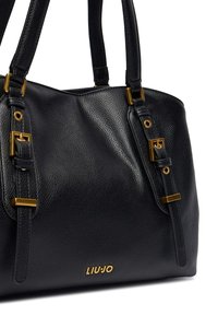 Borsa a mano in pelle nera con superficie strutturata, dettagli in metallo dorato e doppi manici. Presenta un logo del marchio sul fondo.