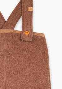 Braune Wollhandtasche mit verstellbaren Schulterträgern, Holzknopfverschluss und kontrastierenden beigen Nähten. Weiche Textur und schlichtes Design.