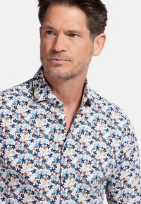 Bloemmotief overhemden in het wit, met blauwe, oranje en donkere accenten. Zachte stof met een standaard kraag en zwarte knopen.