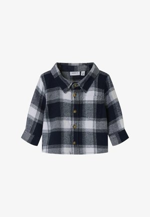 Camisa de cuadros en azul marino y blanco, con mangas largas, que presenta un cuello y cierre frontal con botones. Tejido suave con un patrón a cuadros.