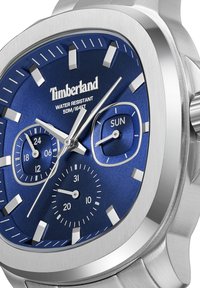 Orologio quadrato in acciaio inox con quadrante blu testurizzato, indici delle ore in argento, due sottodial e display della data. Resistente all'acqua fino a 50m.