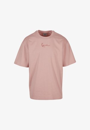 T-shirt rose clair à manches courtes avec col rond et petit texte en cursive « Kane » brodé en rouge au centre de la poitrine.