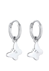 Sølvøreringe med øreringe i form af ørehuller, der har sommerfuglecharme med glatte overflader og diskret gravering. Designet er minimalistisk og organisk.