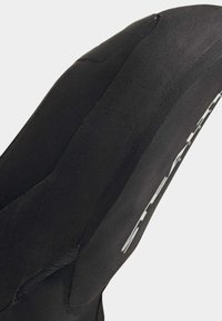 Crne penjačke cipele s glatkom mat površinom, asimetričnim dizajnom i teksturiranom gumom potplatom. Ima bijelo označavanje sa strane.