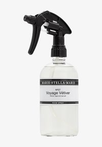 Flacone spray in vetro trasparente con trigger e tappo neri. Etichetta bianca con testo nero, che riporta "Voyage Vétiver" e le note olfattive. Capacità di 500 mL.