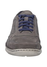 Šedé kožené tenisky s námornickými tkaničkami, s texturovaným designem a perforovaným svrškem. Podešev je světle šedá se švy.