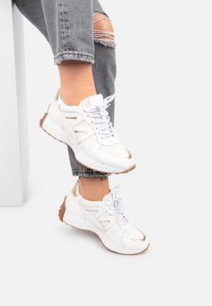 Białe sportowe sneakersy z złotymi akcentami, teksturowaną siateczką i gładkim syntetycznym materiałem. Platformowa podeszwa z gumową podeszwą i sznurowadłami.