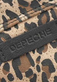 Leopardmönstrad mockakvalitet i beige och brunt med svarta accenter, med en strukturerad svart läderetikett präglad med varumärket.