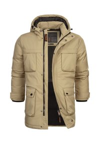 Beige polstret jakke med hette, som har to store frontlommer, glidelås og en myk svart innvendig fôr.