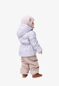 Lyseblå vanntett jakke med snøring i midjen, beige polstrede bukser og brune støvler. Grå hatt med øredetaljer. Synlige sømdetaljer.
