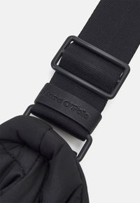 Sangle de sac rembourrée noire avec un corps en nylon texturé, dotée d'une boucle en métal noir mat et d'un accent en cuir gravé du logo.