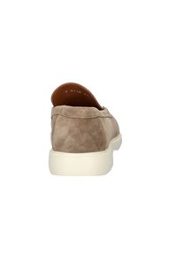 Bruine suède instap schoenen met een gestructureerde afwerking, voorzien van een witte rubberen zool en minimale stiksel details bij de hak.