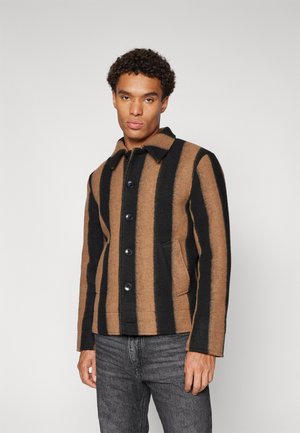Bruine en zwarte gestreepte wollen jas met knopen, een puntige kraag en zijzakken. Gelaagd stof met contrasterende kleuren.