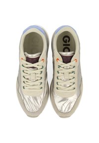 Zapatillas de color claro con un material brillante y reflectante, con cordones beige, acentos multicolores y una suela de goma texturizada.