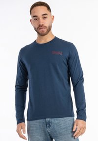 Navy long-sleeve t-shirt made of cotton, featuring a crew neck and a small red logo on the left chest. Smooth texture and fitted design.