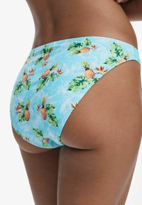 Plavkové spodné diely vo svetlomodrom materiáli s potlačou ananásov a listov. Majú bezšvový dizajn a jemnú textúru, vhodné na plážovú módu.
