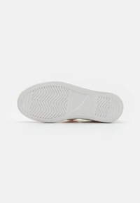 Witte sneakersole met een gestructureerd visgraatpatroon, een glad centraal gedeelte en afgeronde randen. Schone uitstraling, geschikt voor verschillende stijlen.