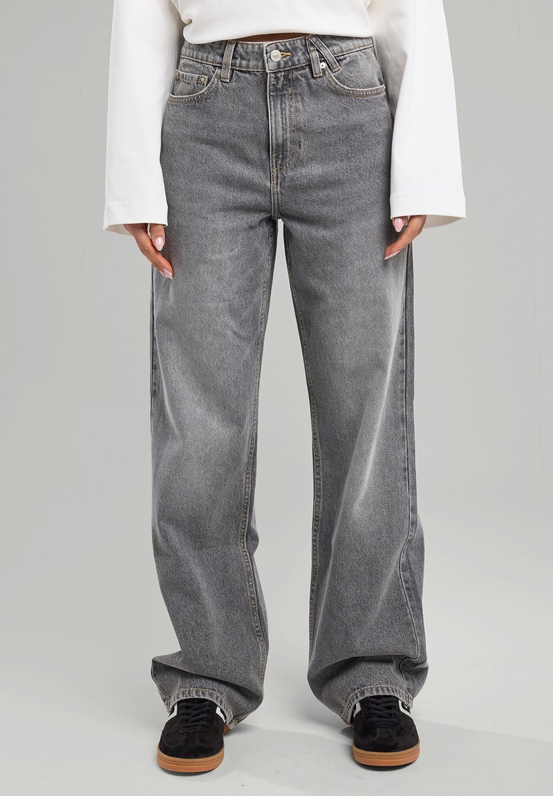 Jeans de tiro alto y pierna ancha en denim gris desgastado, con un sutil efecto de lavado, que cuentan con un diseño clásico de cinco bolsillos y herrajes metálicos.