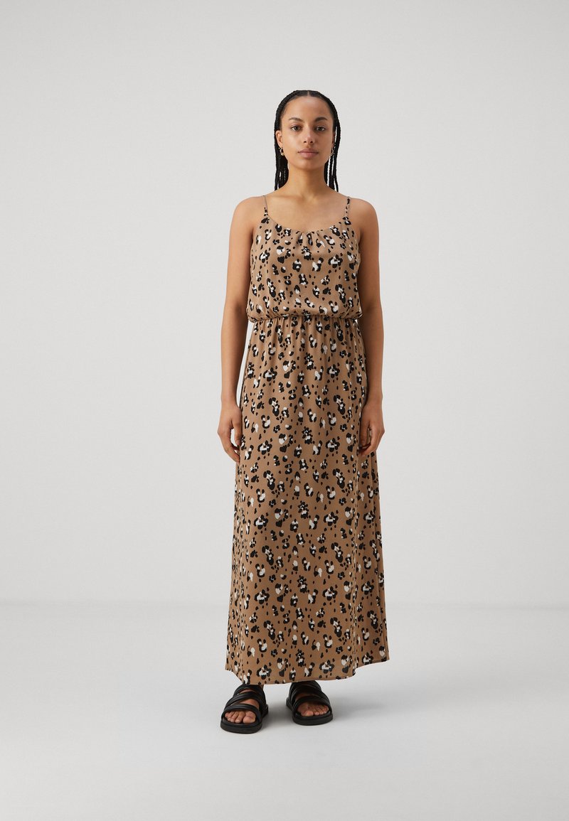 Rochie maxi cu imprimeu leopard în nuanță de bej, cu bretele subțiri ajustabile, talie elastică și material fluid. Asortată cu sandale negre.