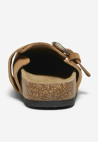 Sandalo in suede marrone con soletta in sughero, cinturino regolabile con elementi metallici e suola nera testurizzata. Vista frontale.