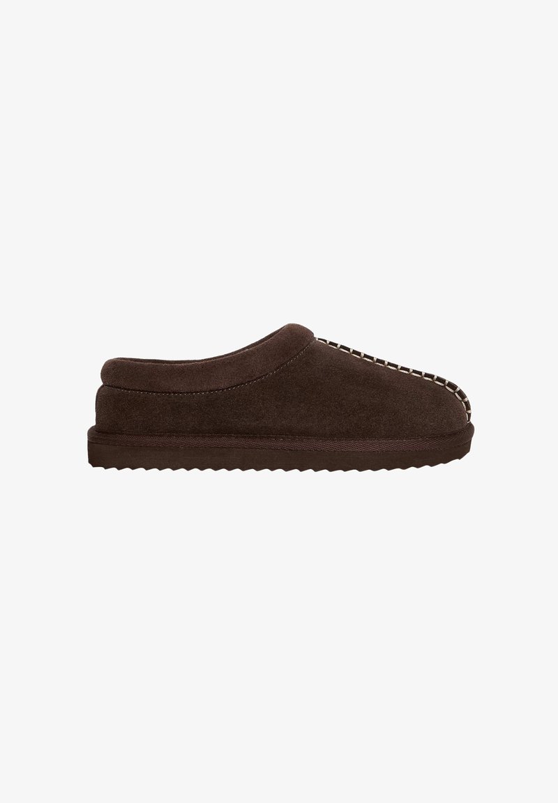 Chausson en daim marron foncé à enfiler avec surpiqûres contrastantes sur le dessus et semelle rainurée pour usage intérieur.